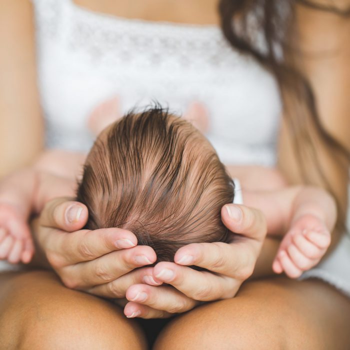 Mother,Holding,Head,Of,Her,Newborn,Son,In,Hands.,The